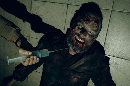 Zombie and Doctor with cure vaccine syringe in hand. Halloween concept.の写真素材