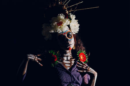Woman with mexican skull halloween makeup on face. Day of the dead aka Dia de los Muertos and halloween concept.の写真素材