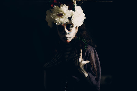 Woman with mexican skull halloween makeup on face. Day of the dead aka Dia de los Muertos and halloween concept.の写真素材