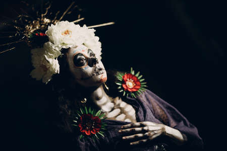 Woman with mexican skull halloween makeup on face. Day of the dead aka Dia de los Muertos and halloween concept.の写真素材