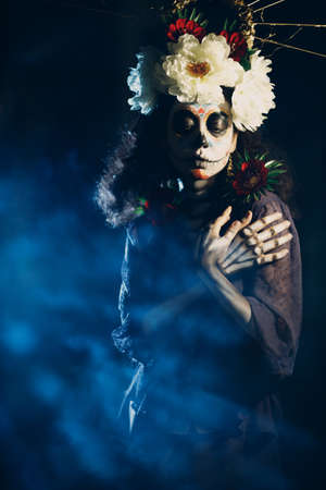 Woman with mexican skull halloween makeup on face. Day of the dead aka Dia de los Muertos and halloween concept.の写真素材