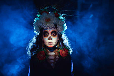 Woman with mexican skull halloween makeup on face. Day of the dead aka Dia de los Muertos and halloween party concept.の写真素材