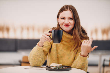 Young woman drinking coffee in the morning at cafe.の写真素材