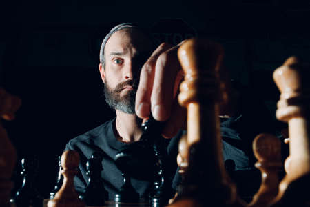 Young adult man player with chess in darkの写真素材