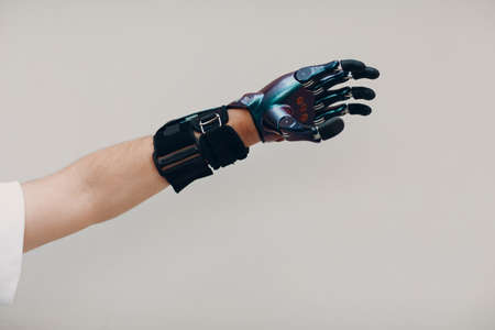 Disabled man with artificial prosthetic hand close up male hand against gray backgroundの写真素材