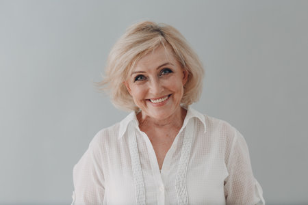 Elderly caucasian old aged woman portrait gray haired smiling portrait. Concept of affordable dentures and implantsの写真素材