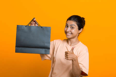 Indian woman holds shopping bags in hands. Sale and Black Friday conceptの写真素材