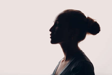 Adult young woman silhouette portrait in studioの写真素材