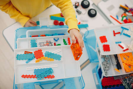 Smiling kid child constructor checking technical toy. Children Robotics constructor assemble robotの写真素材