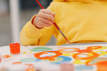Little girl drawing art picture. Painting with brush and gouache paintsの写真素材