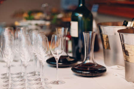 the waiter pours elite red wine into the decanter on the table in the restaurant.の写真素材