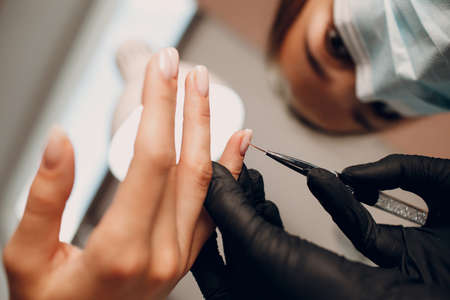 Manicure process female hands finger nails polish.の写真素材