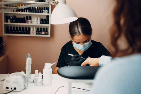 Manicure process female hands finger nails polish.の写真素材