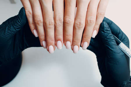 Manicure process female hands finger nails polish checking.の写真素材