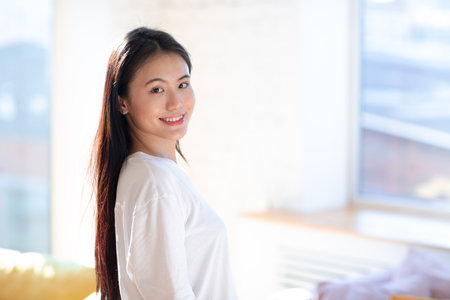 Portrait of smiling asian woman on apartment interior background.の写真素材