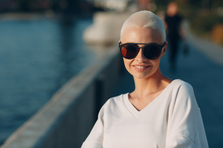 Portrait of young smiling millenial european short haired woman in sunglasses. Beautiful happy blonde 20s girl outdoor. Summer fashion female clothing.の写真素材