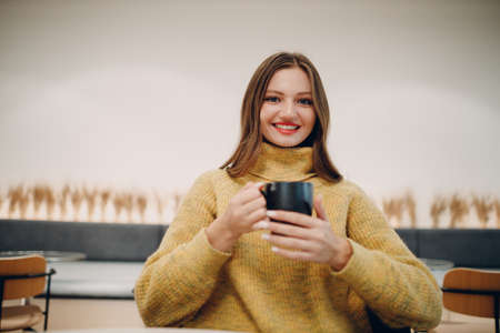 Young woman 20s years old drinking coffee in the morning at cafe.の写真素材
