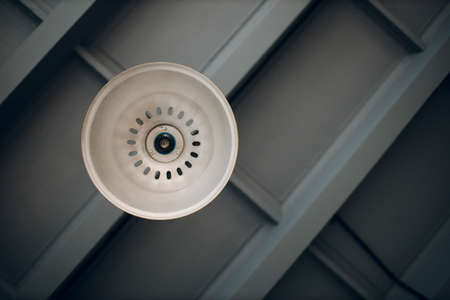Modern minimalistic light plafond fixture under a wooden ceilingの写真素材
