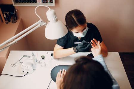 Manicure process female hands finger nails polish at nail salonの写真素材