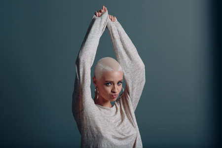 Millenial young woman with short blonde hair portrait hands upの写真素材