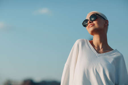 Portrait of young smiling millenial european short haired woman in sunglasses. Beautiful happy blonde girl outdoor. Summer fashion female clothing.の写真素材