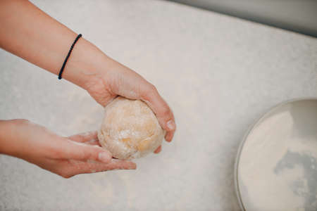 Female hands kneading dough in bowl on table close up. Winter holiday.の写真素材