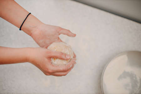 Female hands kneading dough in bowl on table close up. Winter holiday.の写真素材