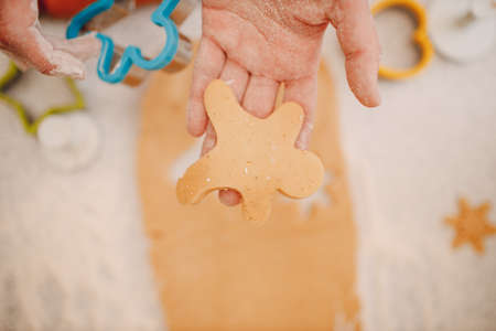 Woman hands form molds cutters ginger dough and makes delicious christmas ginger cookies. Cooking and decorating christmas dessert.の写真素材