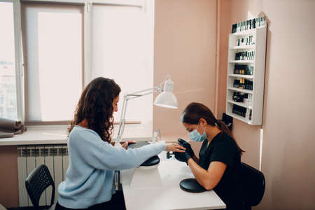 Manicure process female hands finger nails polish.の写真素材