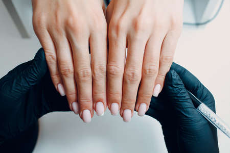 Manicure process female hands finger nails polish checking.の写真素材