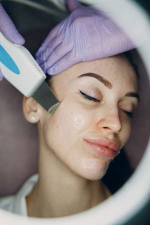 Woman receiving cleansing therapy with a professional ultrasonic equipment in cosmetology beauty spa.の写真素材