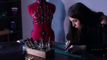 Embossing Cerving Stamping Tooling Modeling Leather. Tanner woman making leather bag belt patternの写真素材