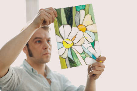 Restorer master male checking stained glass window project