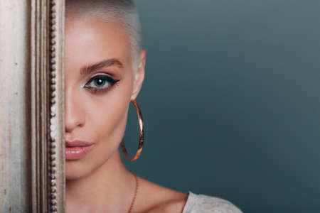 Baguette Framing Workshop Concept. Girl with short blonde hair with gold picture frame portrait.