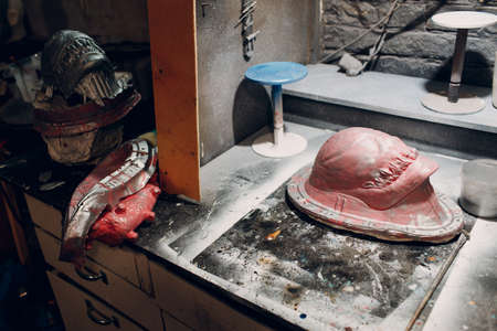 Artisan craftsman create mask based on plaster cast. Gypsum mold and plastic mask sculpting.