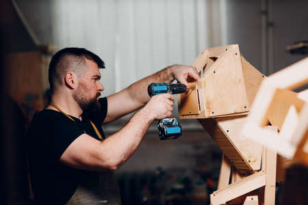 Artisan craftsman carpenter sculptor frame wooden create carcass framework. Wooden board, plywood...