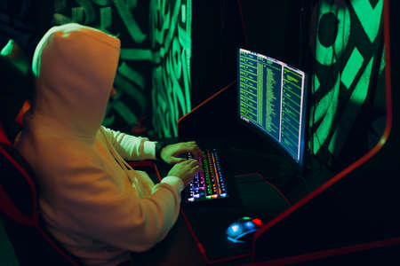 Hacker using computer malware software and hacking binary code green digital interface.の写真素材