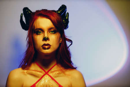 Beautiful young woman with makeup zodiac signs of Capricorn or Aries or Taurus. Girl with horns on...