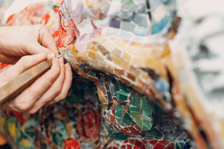 Man mosaics master in hat making smalt glass mosaic panel. Male mosaicist at workの写真素材