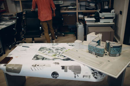 Architect with blueprints and layout design project at office bureauの写真素材