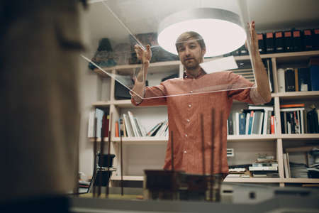 Architect with blueprints and layout design project at office bureau