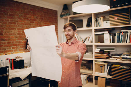 Architect with blueprints and layout design project at office bureau