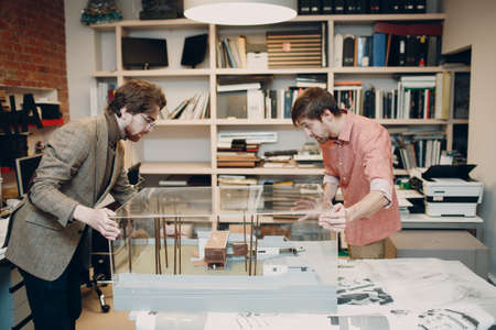 Architect with blueprints and layout design project at office bureauの写真素材