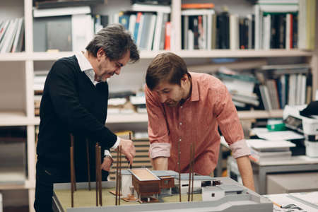 Architect with blueprints and layout design project at office bureauの写真素材