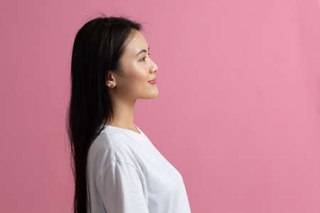 Portrait profile view of asian woman on pink background.の写真素材
