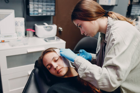 Young woman doing ear piercing at beauty studio salon