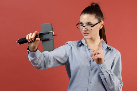 Woman vlogger or blogger live broadcasting video clip by smartphone sharing on social media.の写真素材
