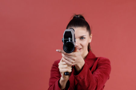 Woman with old vitage movie camera studio shot isolated.の写真素材
