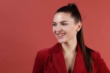 Young smiling caucasian 30s woman in red velvet jacket face portrait.の写真素材