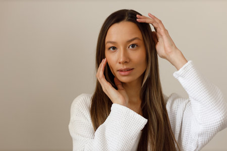 Young asian woman doing face building yoga and facial gymnastics self massage and rejuvenating exercises procedure.の写真素材